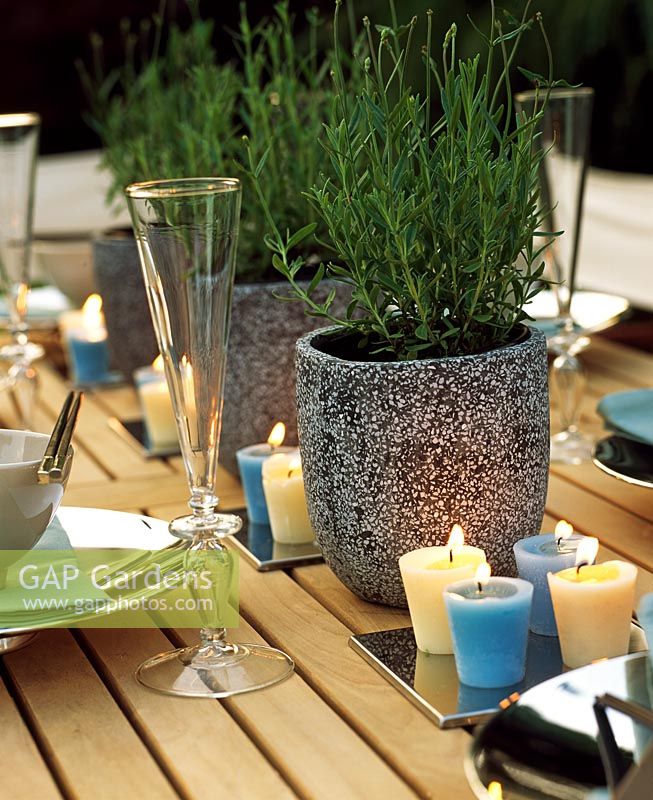Set de table avec bougies, verres et pots de romarin