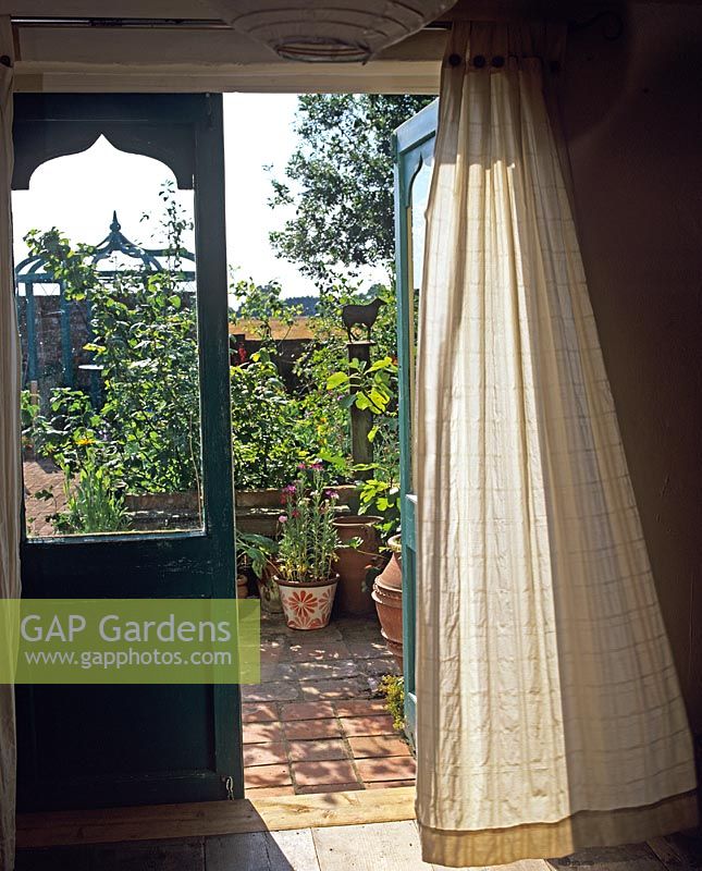Vue à travers les portes-fenêtres du jardin potager en été