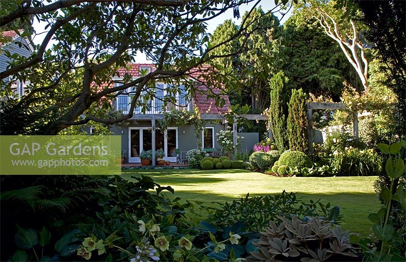 Jardin de campagne avec pelouse bien entretenue. Maison peinte en gris avec des tuiles en terre cuite. Christchurch, Nouvelle-Zélande