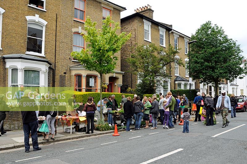 Les gens à la vente de plantes dans une rue urbaine, Hackney, London, UK