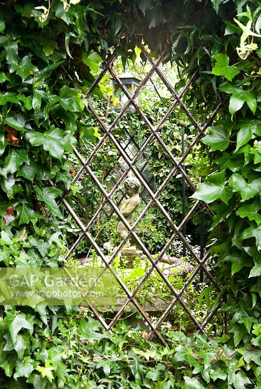 Hedera - Ivy entoure la vue dans le jardin secret avec une pièce d'eau au centre. Le jardin secret de Serles House, Wimborne, Dorset, UK