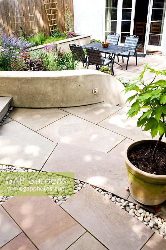 Incurver les marches de calcaire dans un petit jardin moderne.