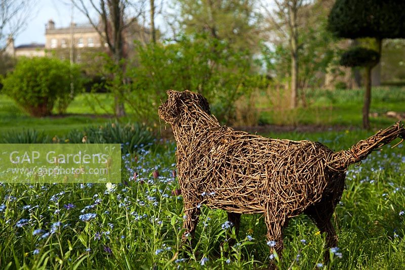 Sculpture de chien et fleurs de printemps dans le Stumpery, Highgrove Garden, avril 2010.