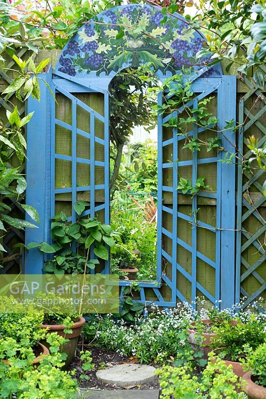 Miroir de jardin avec bordure peinte en bleu et peinture sur le thème 'Homme vert' en haut
