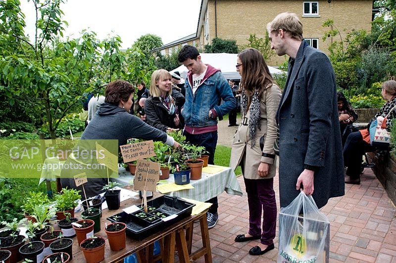Les jeunes d'acheter des plantes de décrochage au King Henry's Walk Garden, lotissements de la communauté urbaine, London Borough of Islington, Royaume-Uni