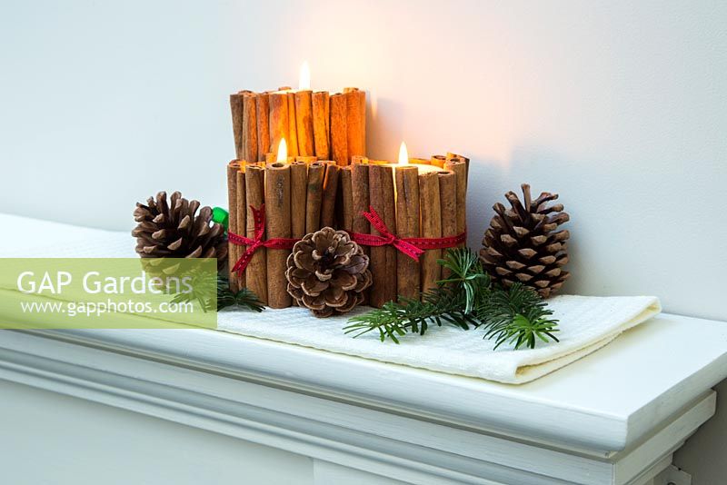 Décorations de bougies de Noël faites à l'aide de bâtons de cannelle et de ruban