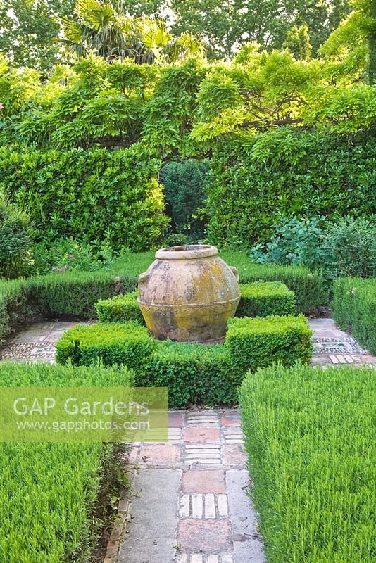Un petit jardin clos de romarin taillé et de buis et un grand pot en terre cuite. Les Confines, Provence, France