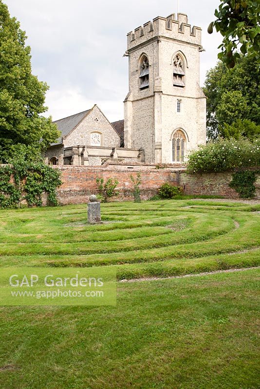Labyrinthe dans le potager avec l'église St Michaels au-delà. Chenies Manor, Buckinghamshire