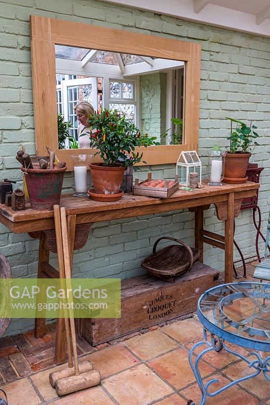 Une véranda avec une sélection d'outils et d'accessoires de jardinage vintage.