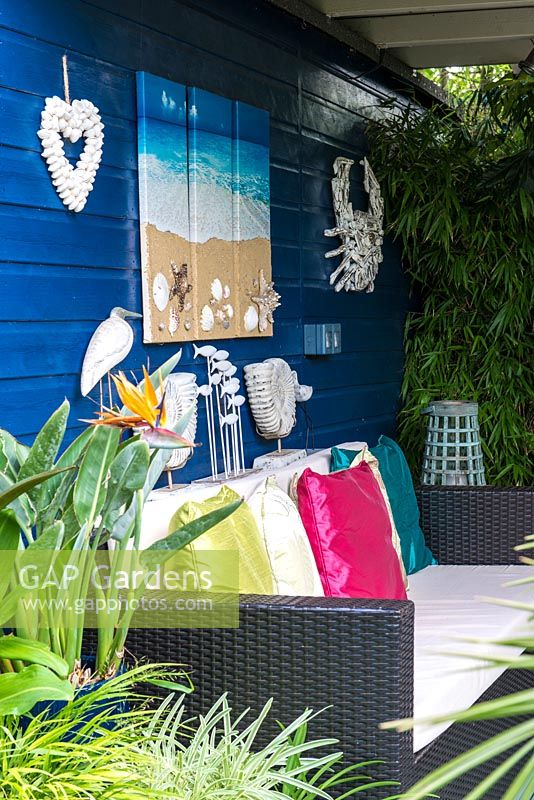 Un coin salon couvert avec des décorations inspirées de la mer et un canapé.