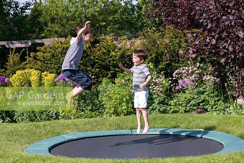 Oscar, Archie, 9 et 7 ans, sur le trampoline, s'est installé dans la pelouse.