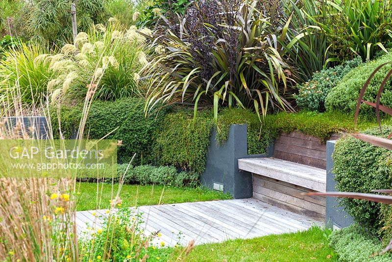 Banc intégral en bois et terrasse en bois au jardin Bhudevi Estate, Marlborough, Nouvelle-Zélande.