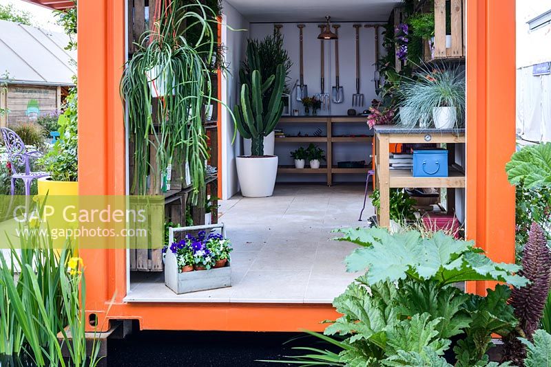 L'intérieur d'une caisse d'expédition orange utilisée comme hangar de mise en pot au RHS Greening Grey Britain pour la santé, le bonheur et l'horticulture. RHS Chelsea Flower Show 2016 - Designer: Annie-Marie Powell