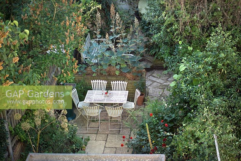 Jardin arrière urbain avec mobilier de jardin, dallage, chauffe-terrasse et dallage