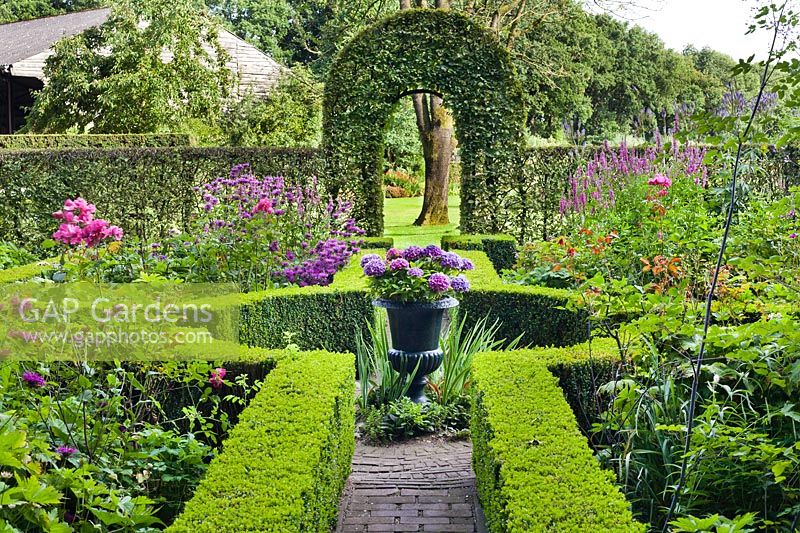 Jardin de noeud avec urne décorative plantée d'hortensia.