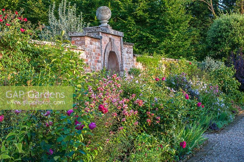 Jardin potager clos Lilium speciosum 'Black Beauty' et Clematis viticella 'Emilia Plater' - Morton Hall Gardens, Worcestershire