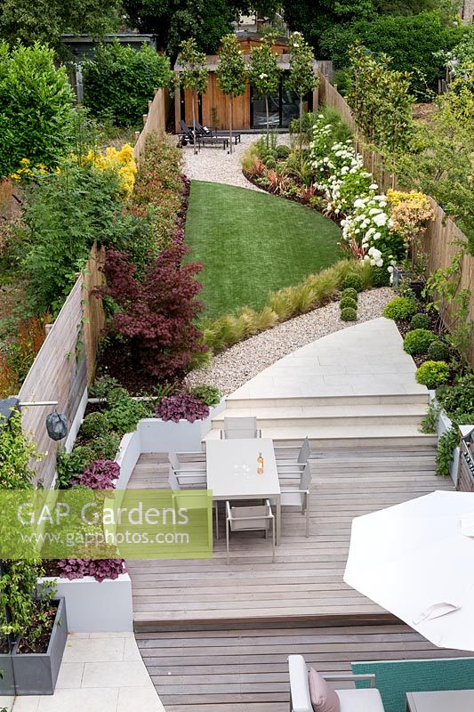 Vue élevée du jardin contemporain avec terrasse en bois et terrasse en gazon artificiel Jardin contemporain à Dulwich