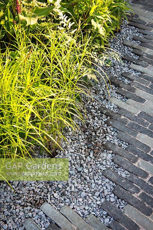 Chemin avec des pavés étroits irréguliers. Le jardin vert d'eau du sud-ouest au RHS Hampton Court Palace Flower Show 2018