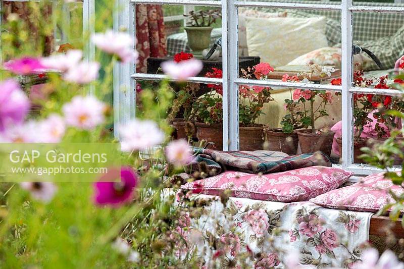 Garden Cottage à Gunwalloe à Cornwall. Jardin de chalet en automne. Assoyez-vous à côté de la véranda avec des coussins vintage à l'ancienne.