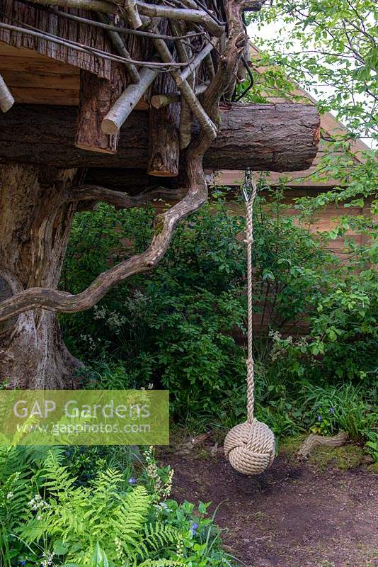 Balançoire pour enfants suspendus à une branche d'arbre sous une cabane dans les arbres - The RHS Back to Nature Garden, RHS Chelsea Flower Show 2019.