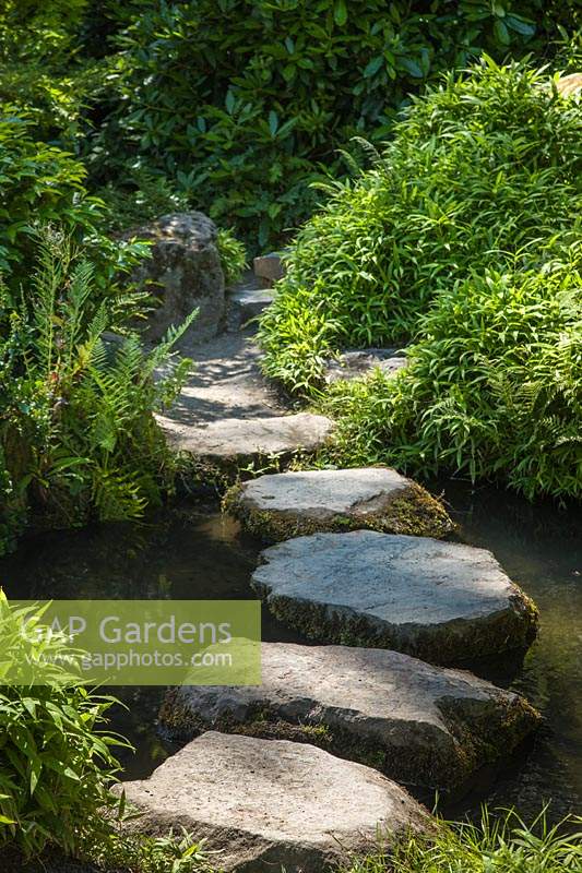 Tremplins à travers un petit ruisseau dans un jardin de style japonais