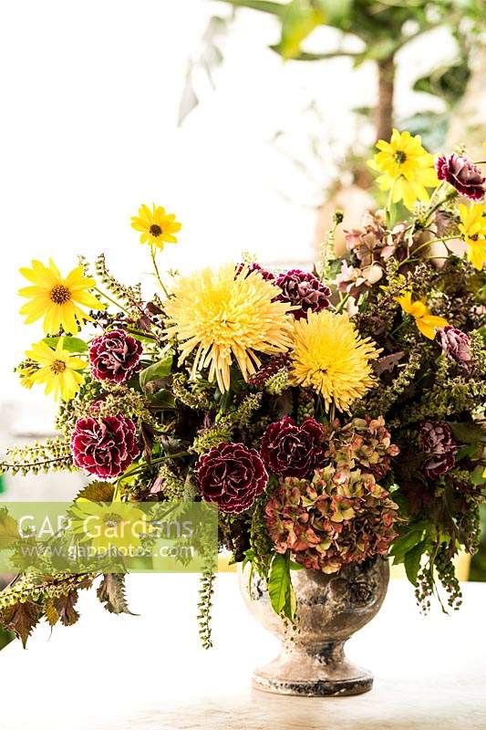 Pot d'Anduze avec arrangement floral, avec Dianthus 'Minerva', Helianthus tuberosus, Chrysanthemum 'Anastasia Sunny', Hydrangea, Coleus et Phytolacca.