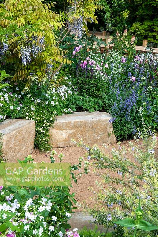 Parterre d'été de plantes vivaces avec des blocs de pierre bordant chemin de gravier - RHS Chelsea Flower Show