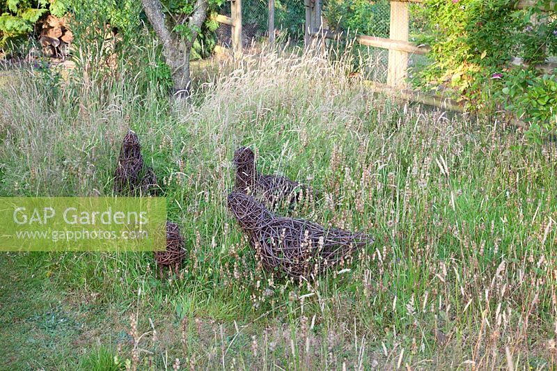 Oiseaux tissés décoratifs dans l'herbe haute