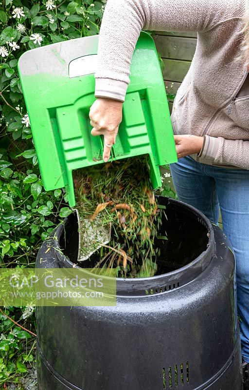 Mélanger l'herbe coupée avec de la terre lors de l'ajout dans un bac à compost.