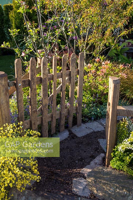 Une porte de jardin en bois rustique, dans un jardin de campagne. The Water Spout garden, RHS Malvern Spring Show, 2016. Concepteur: Christian Dowle