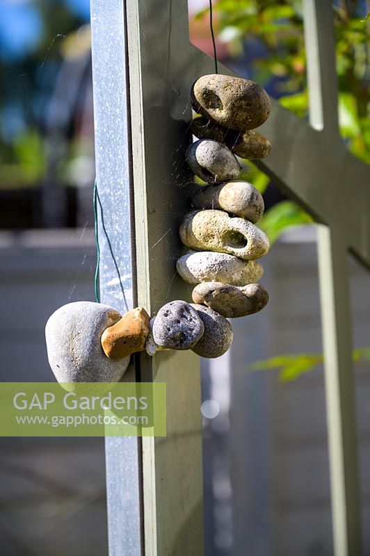 Décoration en pierre à suspendre dans un jardin moderne au nord de Londres par Earth Designs.