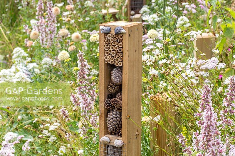Tours d'hôtel d'insectes verticales dans un jardin faunique entouré de fleurs sauvages. Springwatch Garden, Exposition florale de Hampton Court, 2019.
