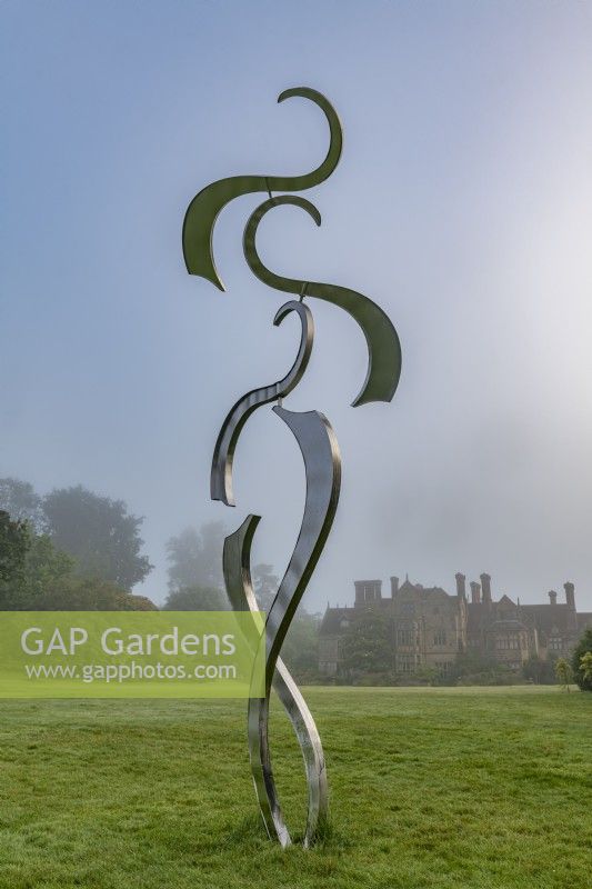 Sculpture contemporaine en métal cinétique sur une pelouse de jardin en été - juillet