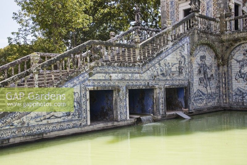 Escalier en pierre du côté du Bassin des Chevaliers. Murs revêtus de tuiles vernissées ou d'azulejos. Petite cascade se jetant dans la piscine. Lisbonne, Portugal, septembre.