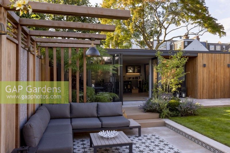 Pergola et patio dans jardin contemporain avec vue vers salon de jardin ou bureau