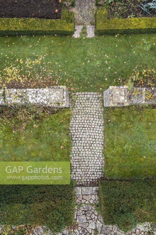 Vue aérienne des surfaces du jardin, y compris la pelouse, le chemin pavé, les murs et les haies