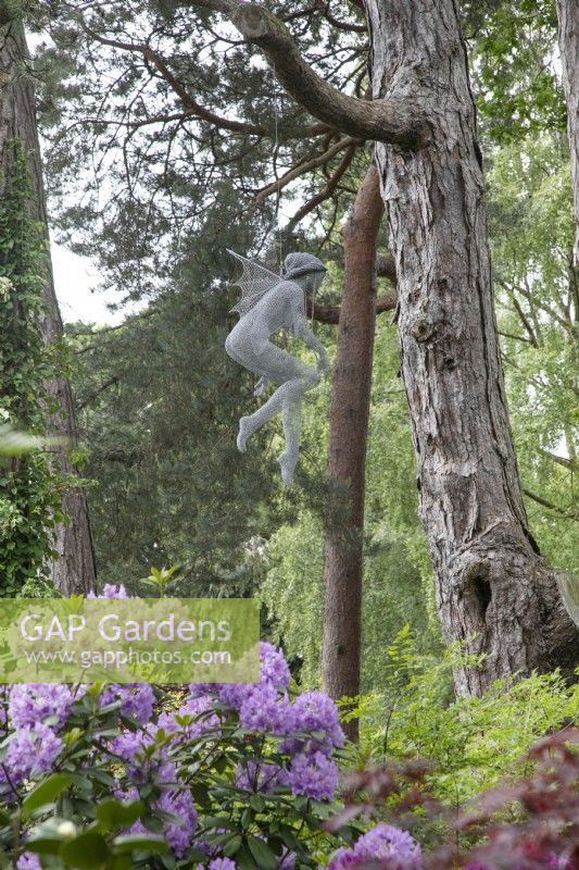 Sculpture en fil de fer d'une fée suspendue dans les arbres, par Derek Kinsett au jardin de Hamilton House en mai