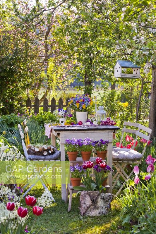 Coin salon dans le jardin de printemps avec arrangement floral.