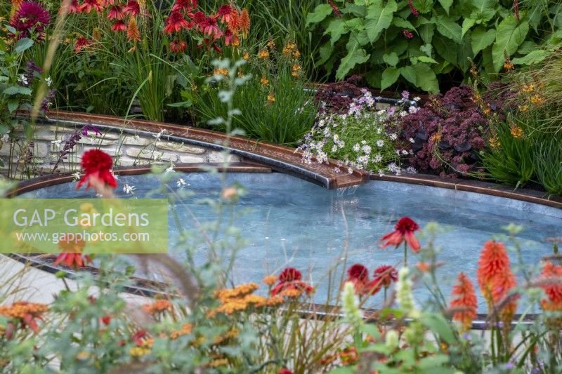 Ruisseau d'eau en cuivre qui coule dans un étang surélevé entouré de plantations colorées - Trouver notre chemin : un jardin d'hommage NHS, RHS Chelsea Flower Show 2021