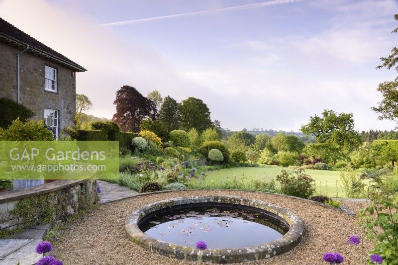 Jardin en terrasse à la française avec bassin circulaire en mai.