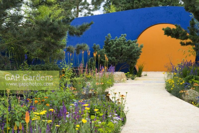 Plantation colorée le long d'un chemin incurvé menant à 'l'ouverture circulaire - Over The Wall Garden, soutenu par Takeda. RHS Hampton Court Palace Garden Festival 2022