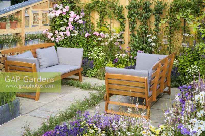 Coin salon entouré de plantations pastel avec des roses roses - Knolling with Daisies, RHS Hampton Court Palace Garden Festival 2022