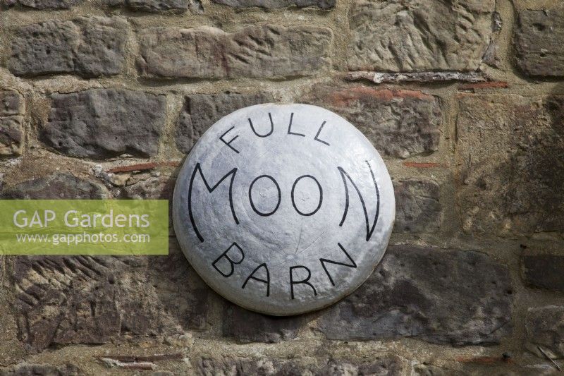Panneau lumineux de la maison de la pleine lune grange sur le mur de pierre rustique
