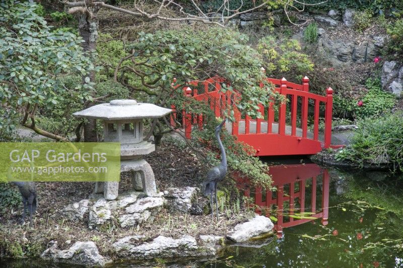 Lampe orientale et pont rouge dans le jardin japonais de Compton Acres, Canford Cliffs, Dorset en mars 