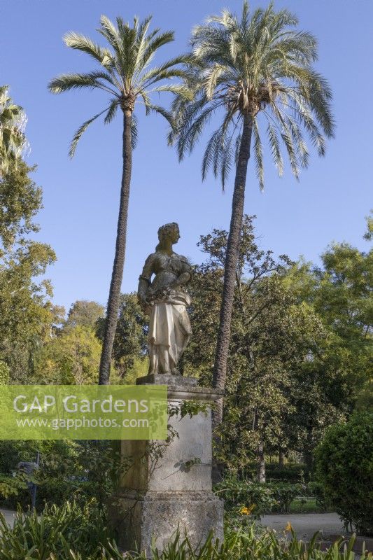 Une statue figurative d'une femme sur un socle en pierre. Parque de Maria Luisa, Séville, Espagne. Septembre 