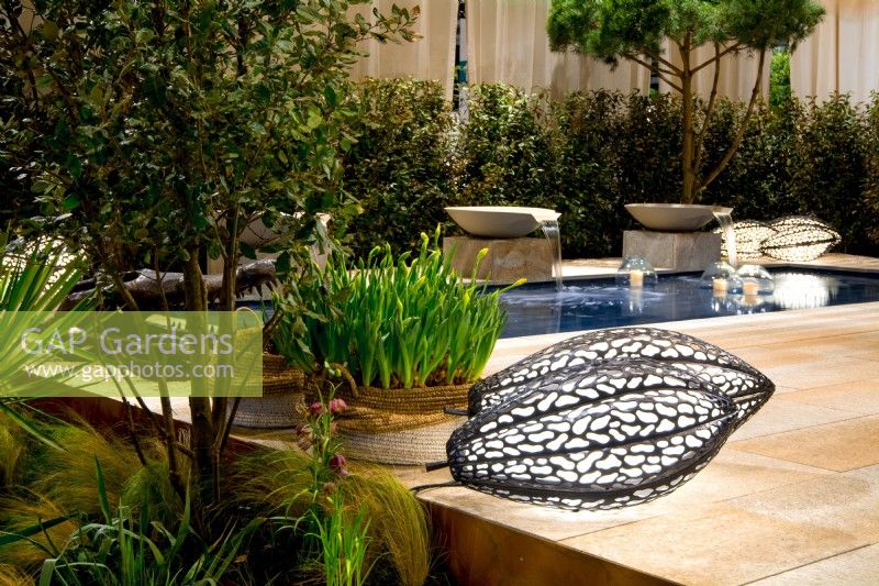 Luxurious African-style terrace with pool and water bowl features. In front, luminescent handmade brass lamps. Plants: Quercus ilex and Narcissus in woven container. Designer: Vetschpartner, Berger Gartenbau and Livingdreams. Giardina-Zurich, Swiss.
Designer: Vetschpartner, Berger Gartenbau and Livingdreams. Giardina-Zurich, Swiss. 

