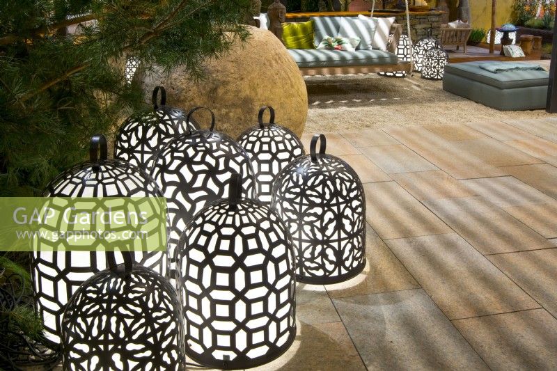 Group of luminescent, handmade brass lamps on natural stone terrace with seating. Designer: Vetschpartner, Berger Gartenbau and Livingdreams. Giardina-Zurich, Swiss.

