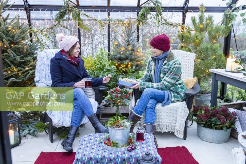 Women sharing food inside decorated greenhouse