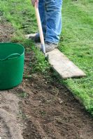 Nettoyer un bord de pelouse droit avec un coupe-demi-lune