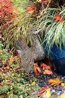 Poulet importé d'Afrique et fabriqué à partir de ferraille sur un pot en verre bleu planté d'herbes pour un effet d'automne.